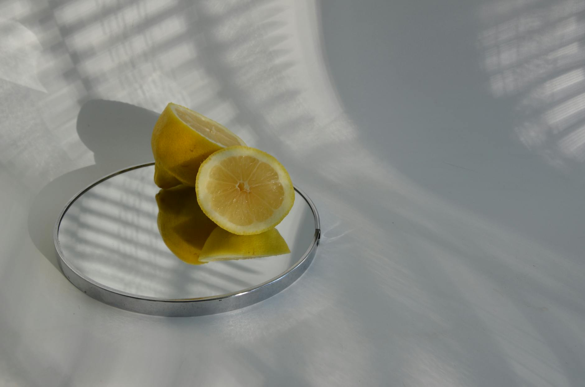 Hand holding a bright orange lemon vibrator against a minimalist purple background