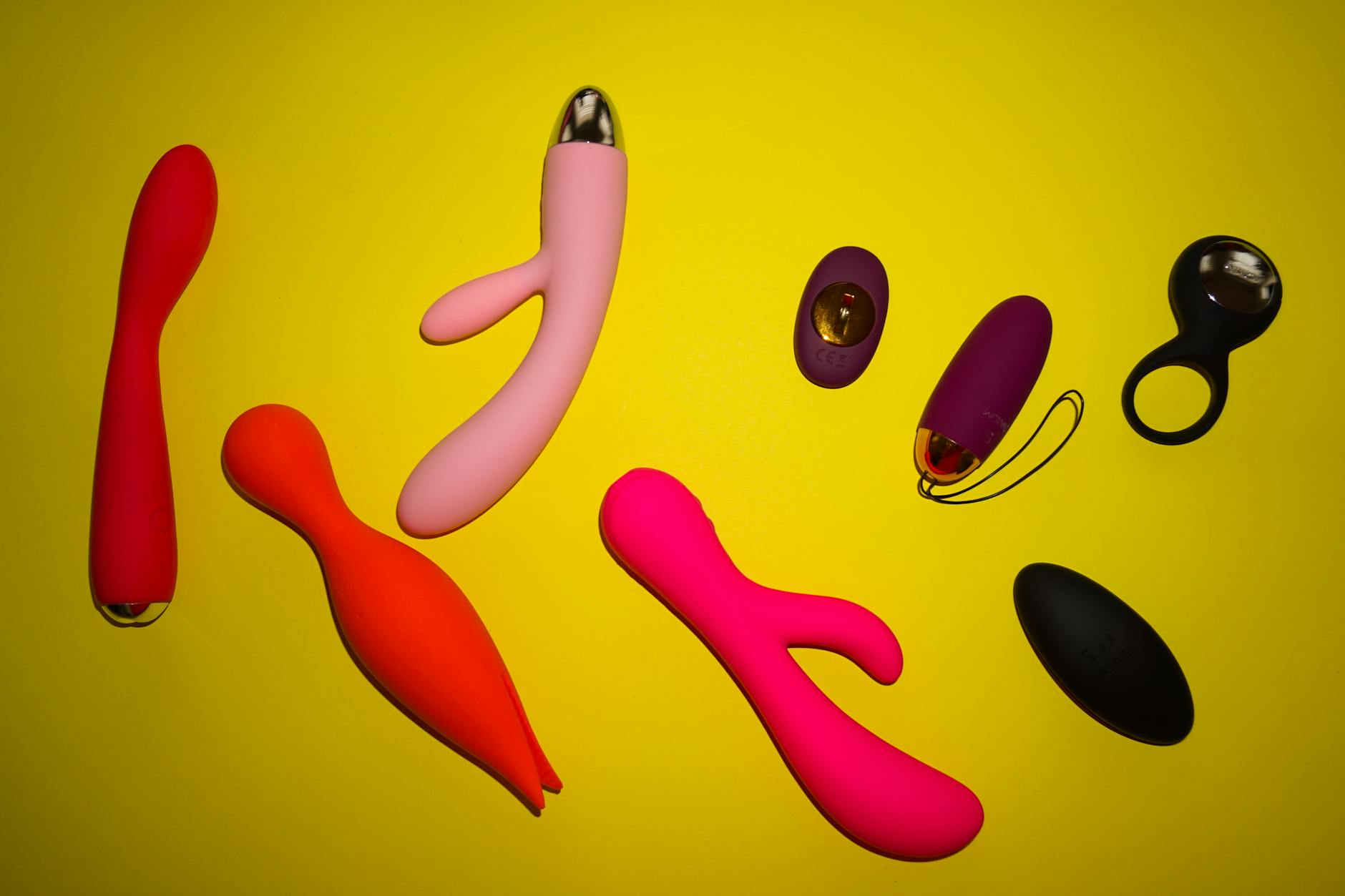 Hand holding a lemon-colored vibrator against a minimalist purple backdrop